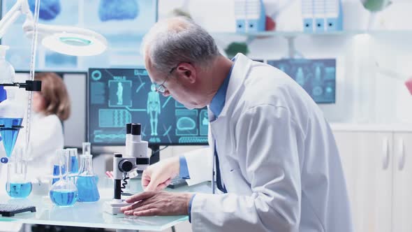 In Modern Research Facility Mature Chemist Is Taking Notes alt