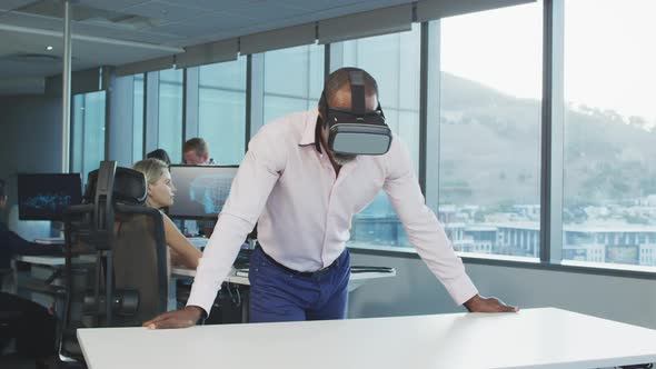 African American businessman wearing VR headset in modern office alt