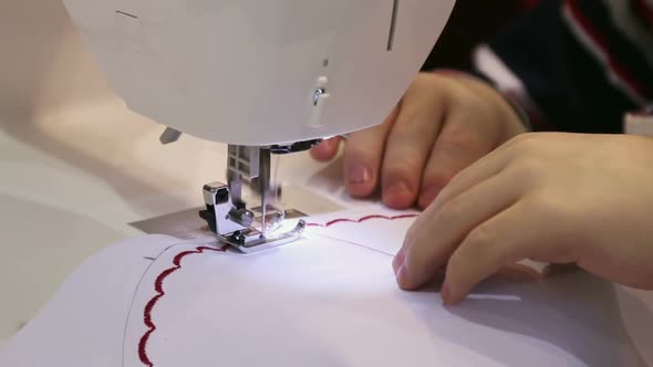 Hands Move the Fabric and Prostrachivajut on the Sewing Machine