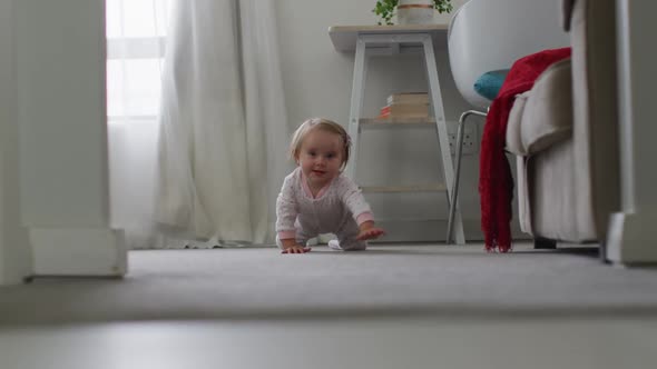 Close up of caucasian baby crawling on the floor at home alt