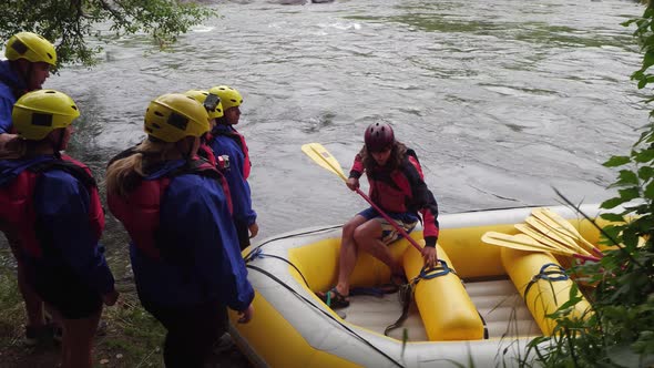 Group of people white water rafting get instructions