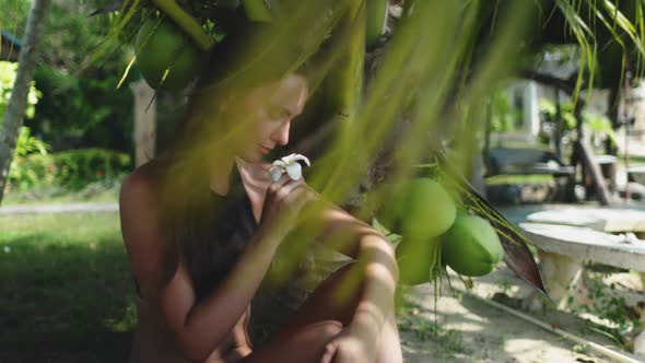 Caucasian Woman Sitting Under Coconut Palm Tree