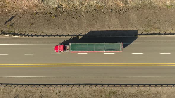 Vertical drone view of highway with few cars driving fast between white lines alt
