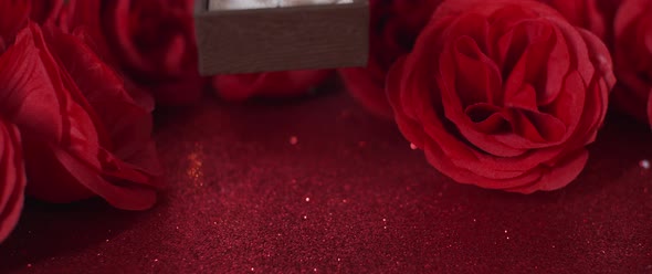 jewelry box placed on red glitter and roses