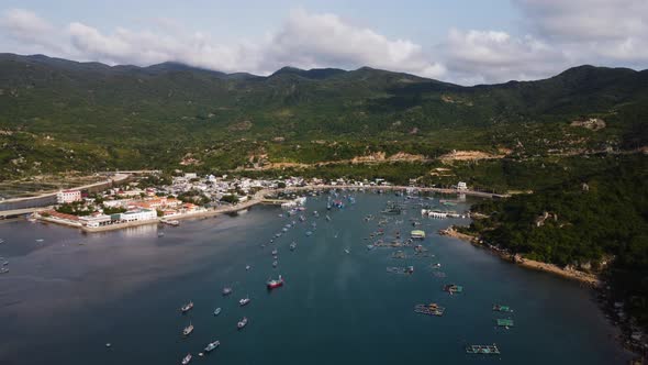 Aerial View Of Fishing Boats Floating In The Calm Sea With Seaside Village In Vietnam. alt
