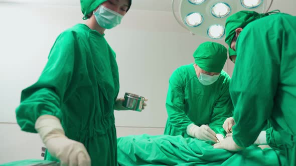 Asian team of professional doctor surgeons and nurses working to starting the operation in hospital alt