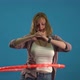 Girl Twists a Hoop on a Blue Background Slow Mo
