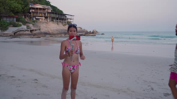 Thai Live Streamer in Bikini Met a Male Friend on a Beach During Broadcasting on Phone Camera alt