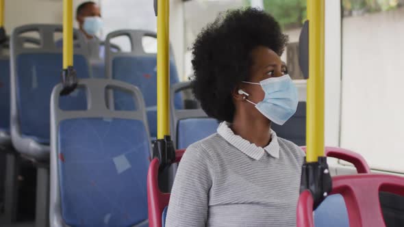 African american businesswoman with face mask sitting in bus alt