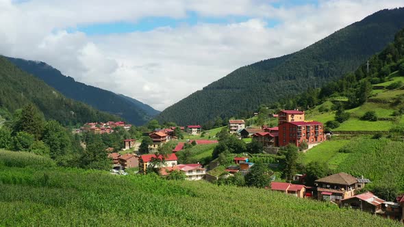 aerial drone flying over a hill revealing a mountain village during a summer morning in Uzungol Trab alt