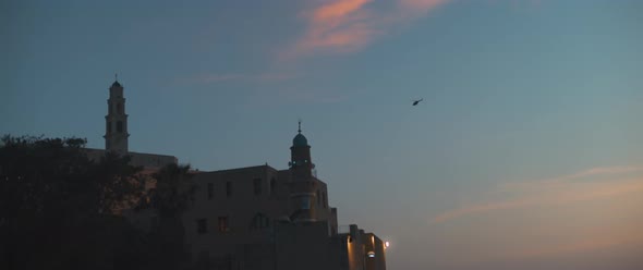 A helicopter fly above an old mosque alt