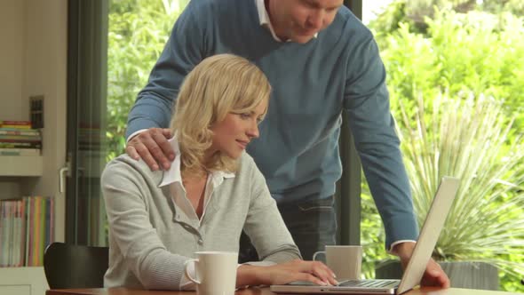 Mid Shot off male and female with laptop buying online and having a break alt