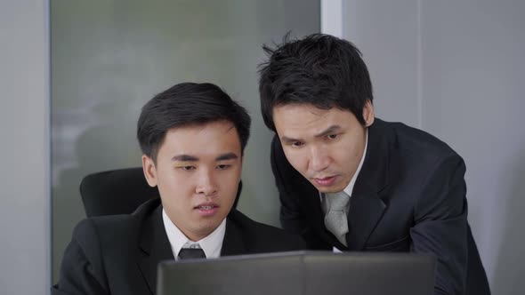 two business man using laptop and discussing project alt