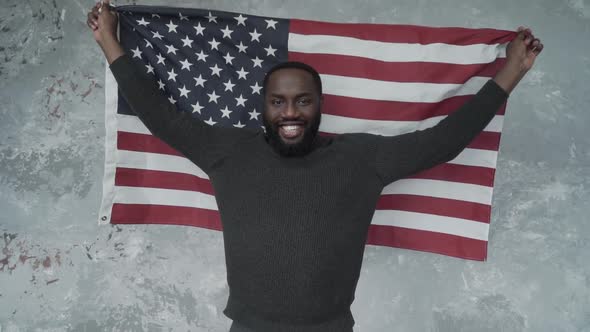 Handsome Happy Afro American Man Is Smiling Standing with American Flag. Looking at Camera alt