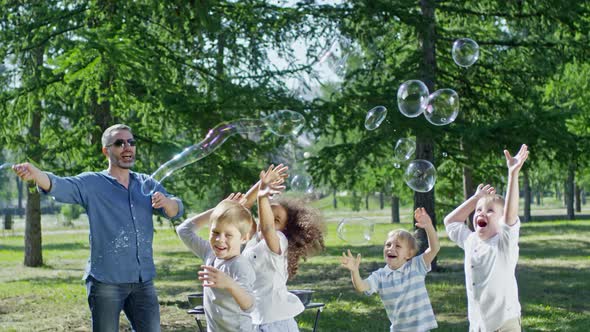 Man Performing Tricks with Soap Bubbles for Children alt