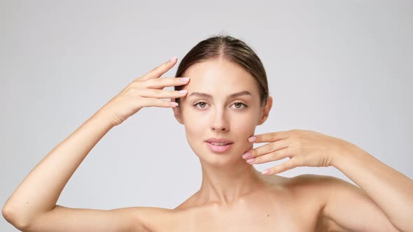 Beautiful Young Woman with Clean Fresh Skin Standing Over Light Grey Background alt