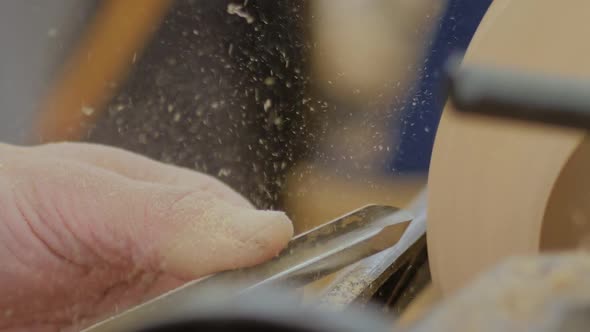 Close Up Carpenter Using Chisel for Shaping Piece of Wood on Lathe Slow Motion