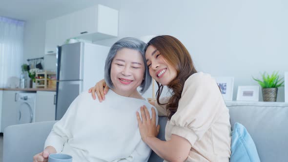 Portrait of Asian lovely family, young daughter hugging older mother enjoy activity at home together alt