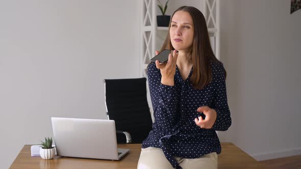 Confident Young Businesswoman Using Voice Recognition Function on a Smartphone alt
