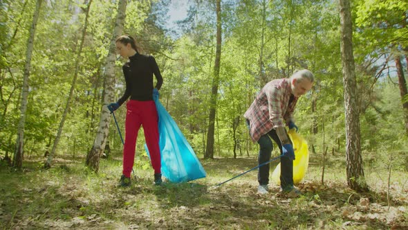 Active Eco Friendly Adult Couple Cleaning Forest From Litter alt