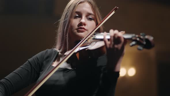 Pretty Woman is Playing Violin on Scene in Music Hall Portrait of Female Musician on Scene of Music alt