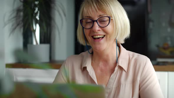Video of happy senior woman during video conference at home. Shot with RED helium camera in 8K. alt