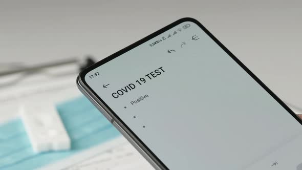 Doctor Writes Covid Swab Results on Smartphone alt
