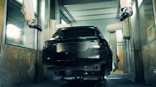 Robotic Arms Spray Painting Car Body Black Car Manufacturing Facility alt