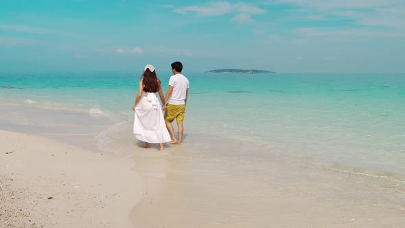 happy young couple walking on the sea beach at Koh MunNork Island, Rayong, Thailand alt