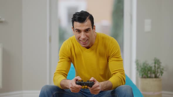 Portrait of Happy Carefree Middle Eastern Man Using Game Console Winning in Video Game alt