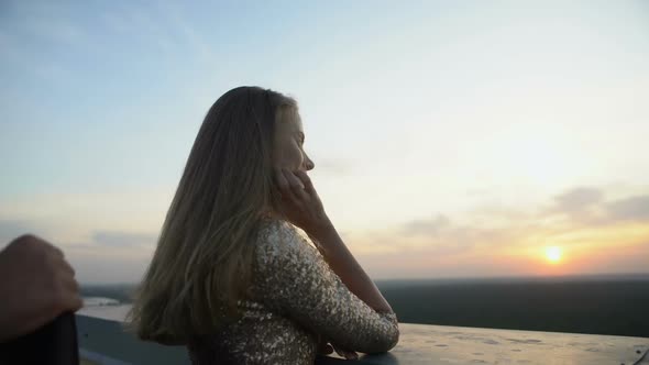 Caring Man Wearing Jacket on Girlfriend Standing on Balcony at Home Party