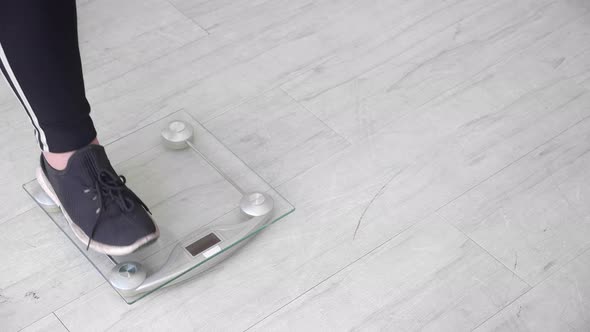 Foot of woman fat dieting standing on scale for weight loss at home. alt