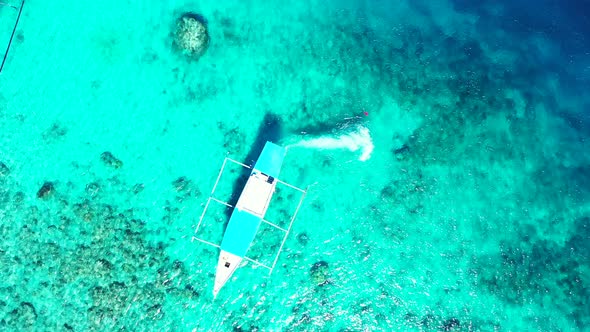 Balinese boat starting motor engine and rotating propellers, tracing on turquoise shallow lagoon wit alt