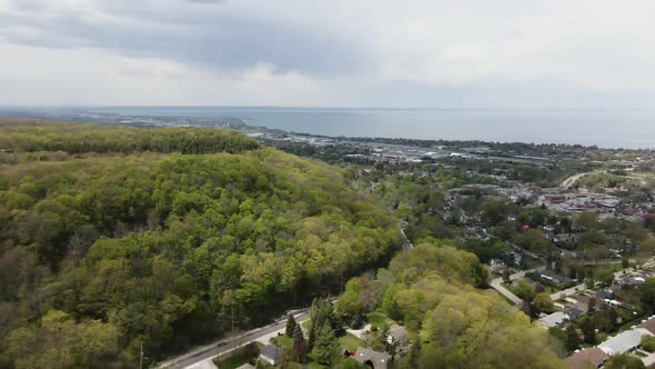 Beautiful aerial flight over natural forest near Grimsby City and Lake Ontario in background. Hamilt alt