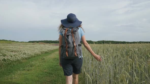 Woman Traveler Walking in The Field with Spikelets