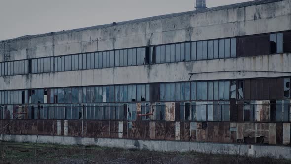 The Facade of an Old Dilapidated Factory with Broken Windows