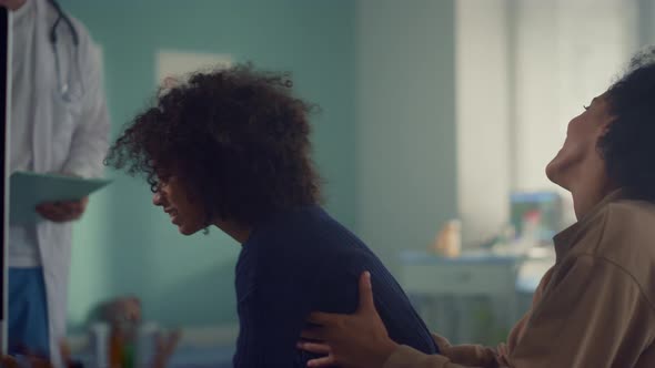 African Family Visiting Pediatrician in Modern Office alt