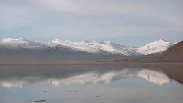 Panoramic Landscape of Lake Surface with Reflections of Mountains on Surface alt