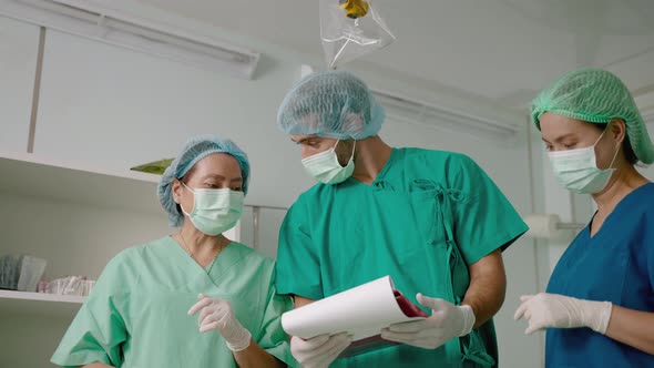 team of doctors and nurses in the operating room are consulting the patient's condition