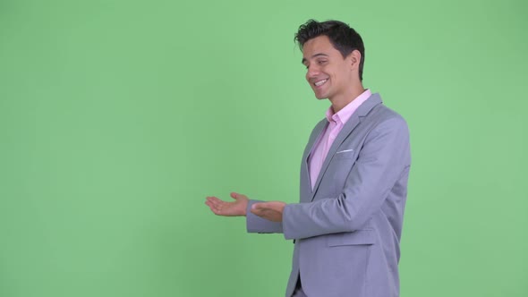 Happy Young Handsome Businessman Talking and Showing To Back alt