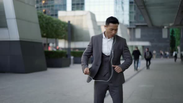 Real Time Portrait Shot of a Young Businessman Dancing with Headphones on the Street During a Break alt