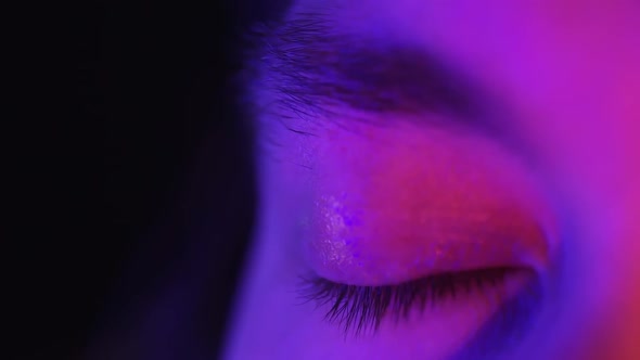 Close Up Macro Blue Eye Opening Beautiful Iris Natural Human in Neon Light. Beauty Healthy Eyesight