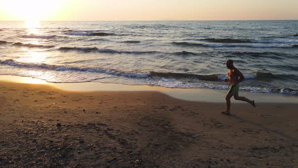 Slow motion shot of senior man jogging at beach alt