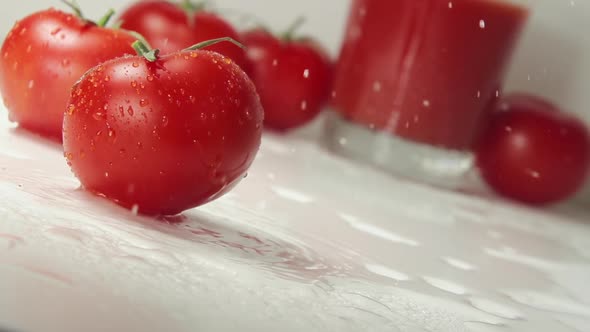 Ripe Tomato Falls On A Table, Splashing Drops