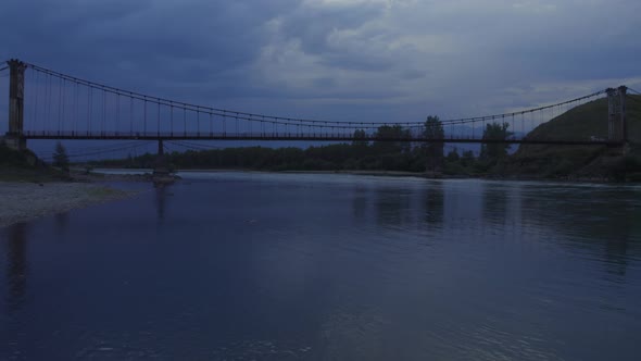 Bridge and river Katun in Altai under sunset sky
