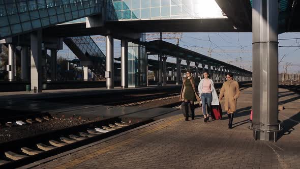 Three Women with Suitcases Go on the Platform of the Railway Station and Talking