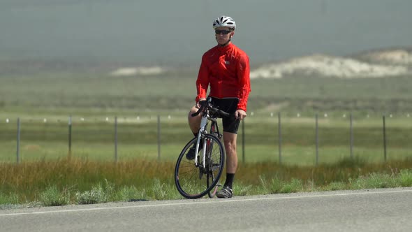 A man road biking on a scenic road. alt