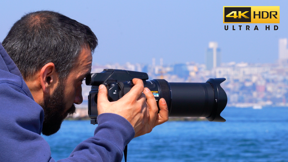 A Man taking picture with zoom lens