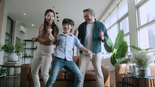 Happiness cheerful asian family dad mom and son funny dancing in living room alt
