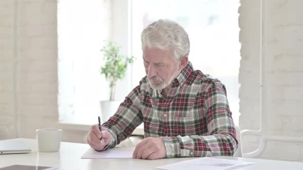 Disappointed Casual Old Man Trying To Write on Paper  alt